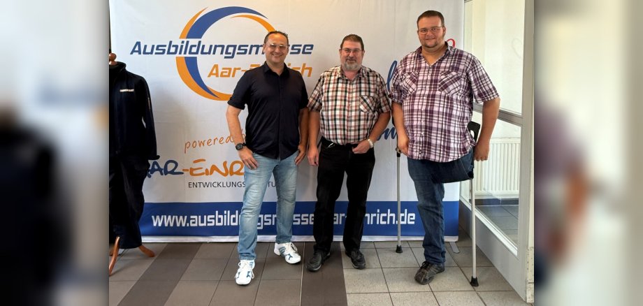 Der Bürgermeister der Verbandsgemeinde Aar-Einrich Lars Denninghoff (Bildmitte) sowie die VG-Mitarbeiter Christopher Kahl (links) und Daniel Schmidt (rechts) gruppierten sich anlässlich der ersten Ausbildungsmesse Aar-Einrich zum Erinnerungsfoto.
Bildquelle: Entwicklungsagentur Aar-Einrich
Der Bürgermeister der Verbandsgemeinde Aar-Einrich Lars Denninghoff (Bildmitte) sowie die VG-Mitarbeiter Christopher Kahl (links) und Daniel Schmidt (rechts) gruppierten sich anlässlich der ersten Ausbildungsmesse Aar-Einrich zum Erinnerungsfoto. Bildquelle: Entwicklungsagentur Aar-Einrich