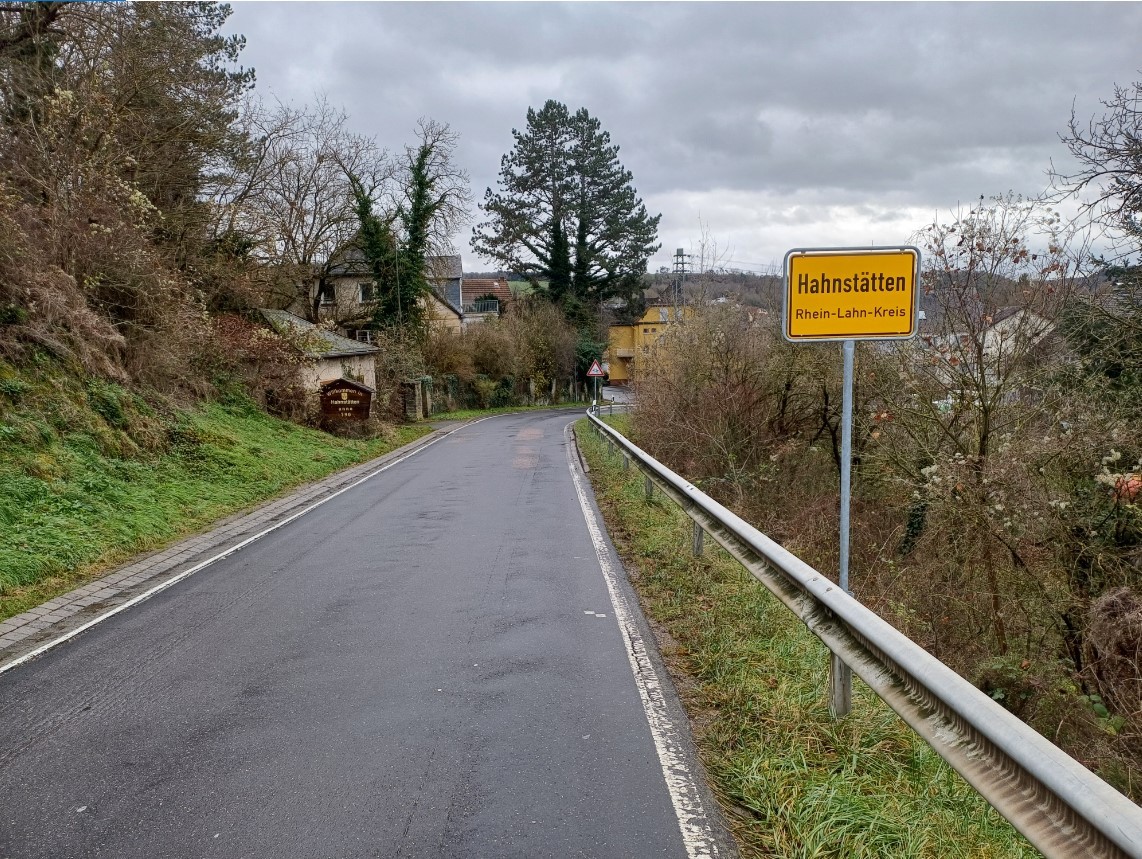 Zu sehen ist die Straße von Netzbach nach  Hahnstätten mit dem Dorfschild von Hahnstätten