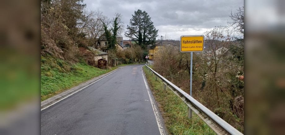 Zu sehen ist die Straße von Netzbach nach  Hahnstätten mit dem Dorfschild von Hahnstätten