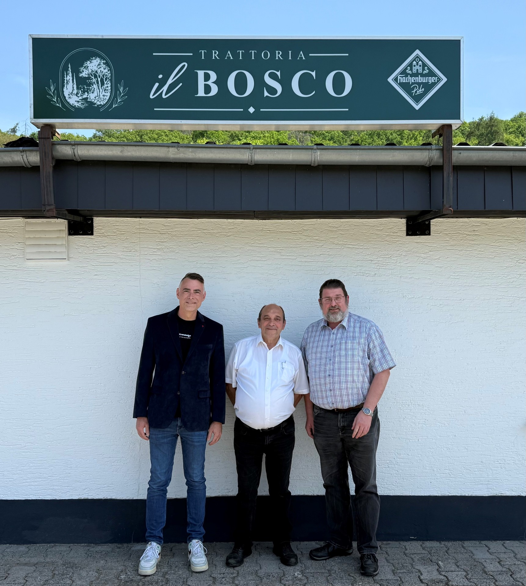 Das Bild zeigt Burgschwalbachs Bürgermeister Daniel Sauerwein (links), VG-Bürgermeister Lars Denninghoff (rechts) sowie den Inhaber der Trattoria Il Bosco, Antonio Errico