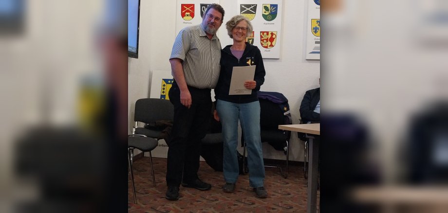 Das Foto zeigt den Bürgermeister der Verbandsgemeinde Aar-Einrich, Lars Denninghoff und Anja Emmel aus Rettert, die für ihr ehrenamtliches Engagement in der Notfallseelsorge ausgezeichnet wurde.